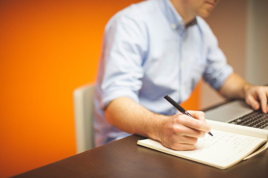 Procurement course photo - person writing notes at a computer