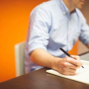 Procurement course photo - person writing notes at a computer